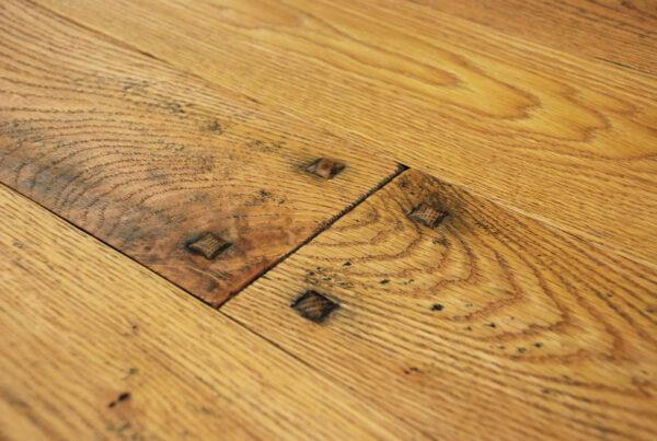 Hand scraped wide plank red oak with raised pegs, smoke accents and Harvest pine colored hard wax oil finish